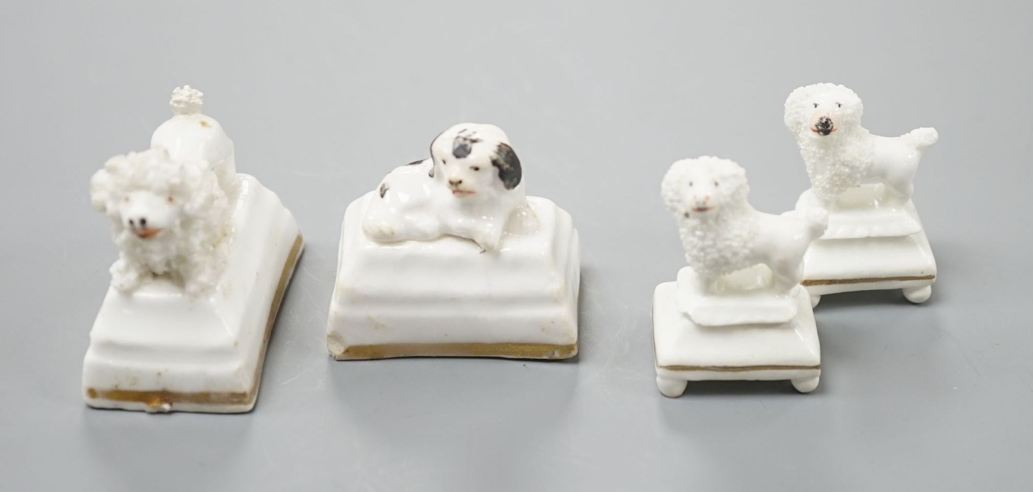 Four Staffordshire porcelain toy models of poodles and a King Charles spaniel puppy, c.1835-50, tallest 3.5 cm, Cf. Dennis G.Rice Dogs in English porcelain, colour plate 154., Provenance: Dennis G.Rice collection